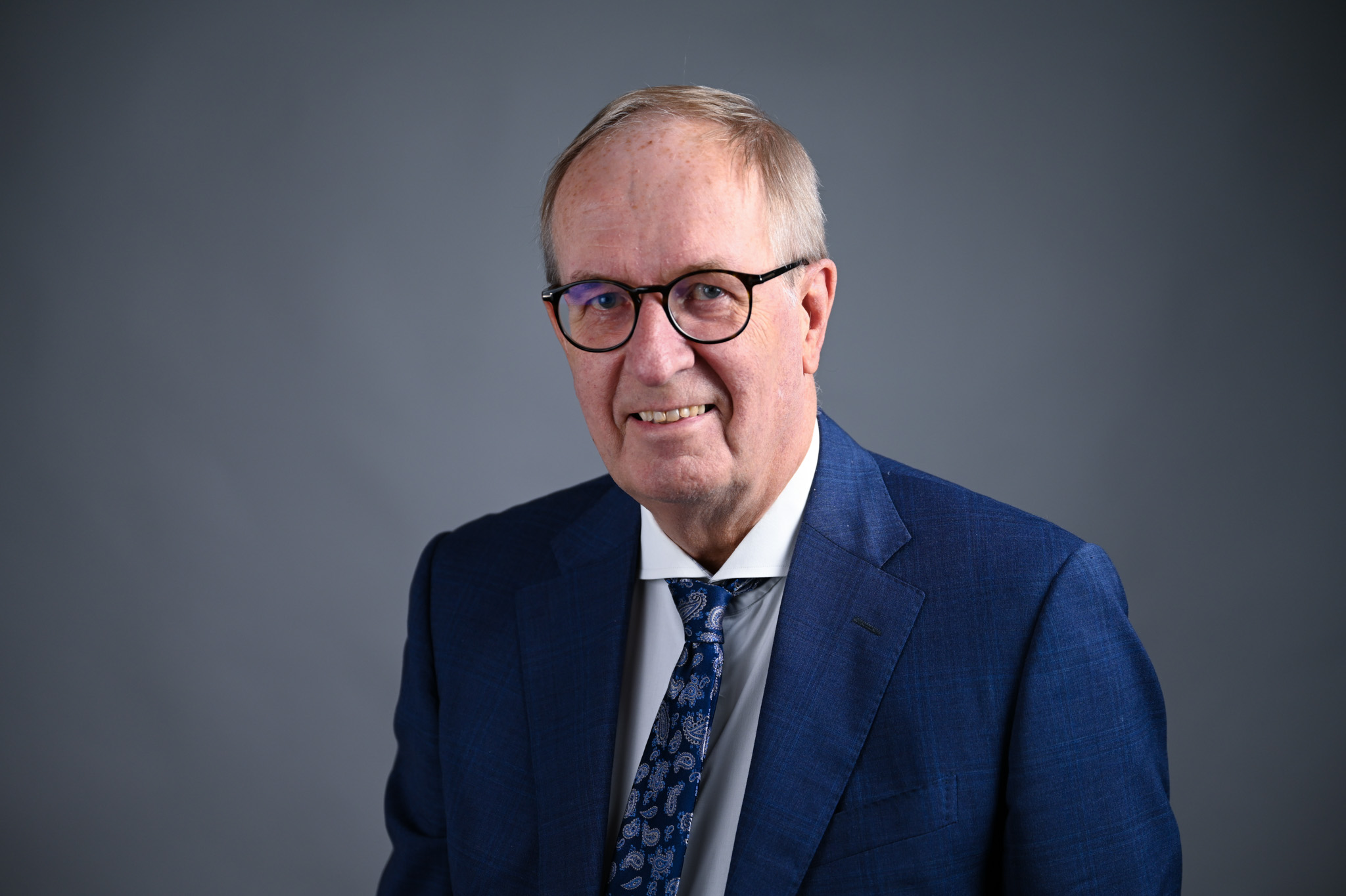 Portrett av mann med grå bakgrunn. Foto: Anders Palmer Holmen