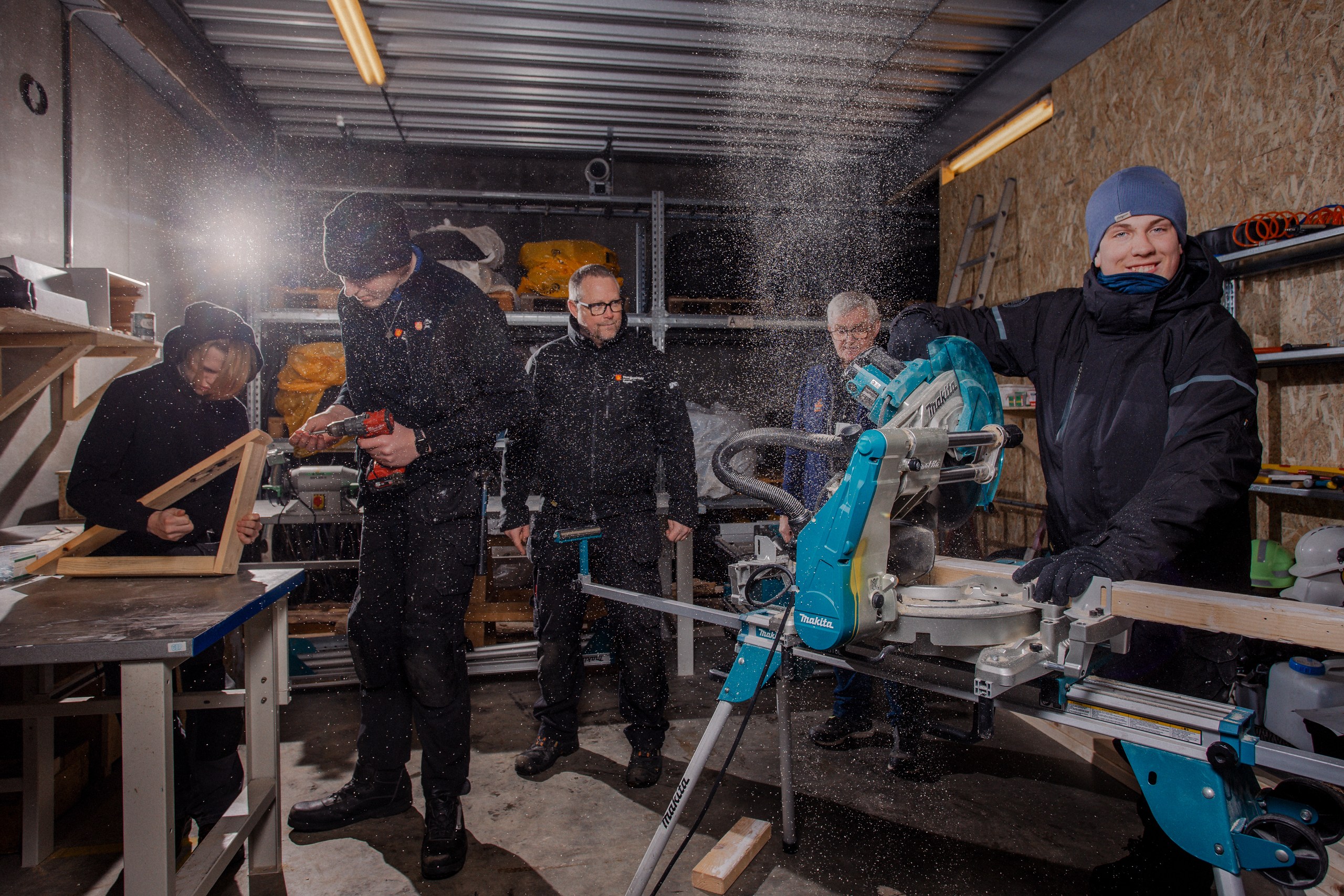 Elever i verkstedet. Kutter plank og skrur.