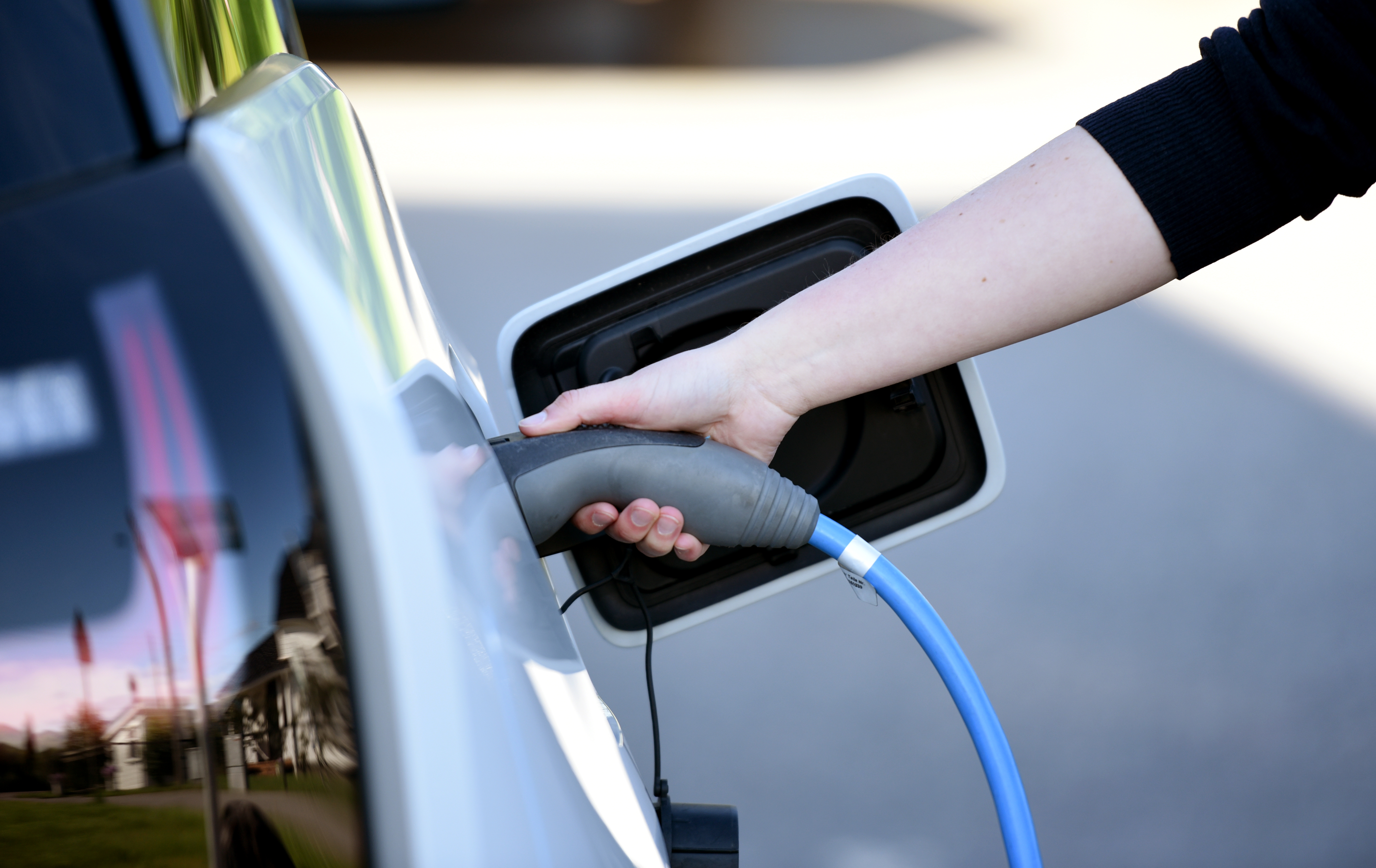 Bilde av hånd som lader el-bil