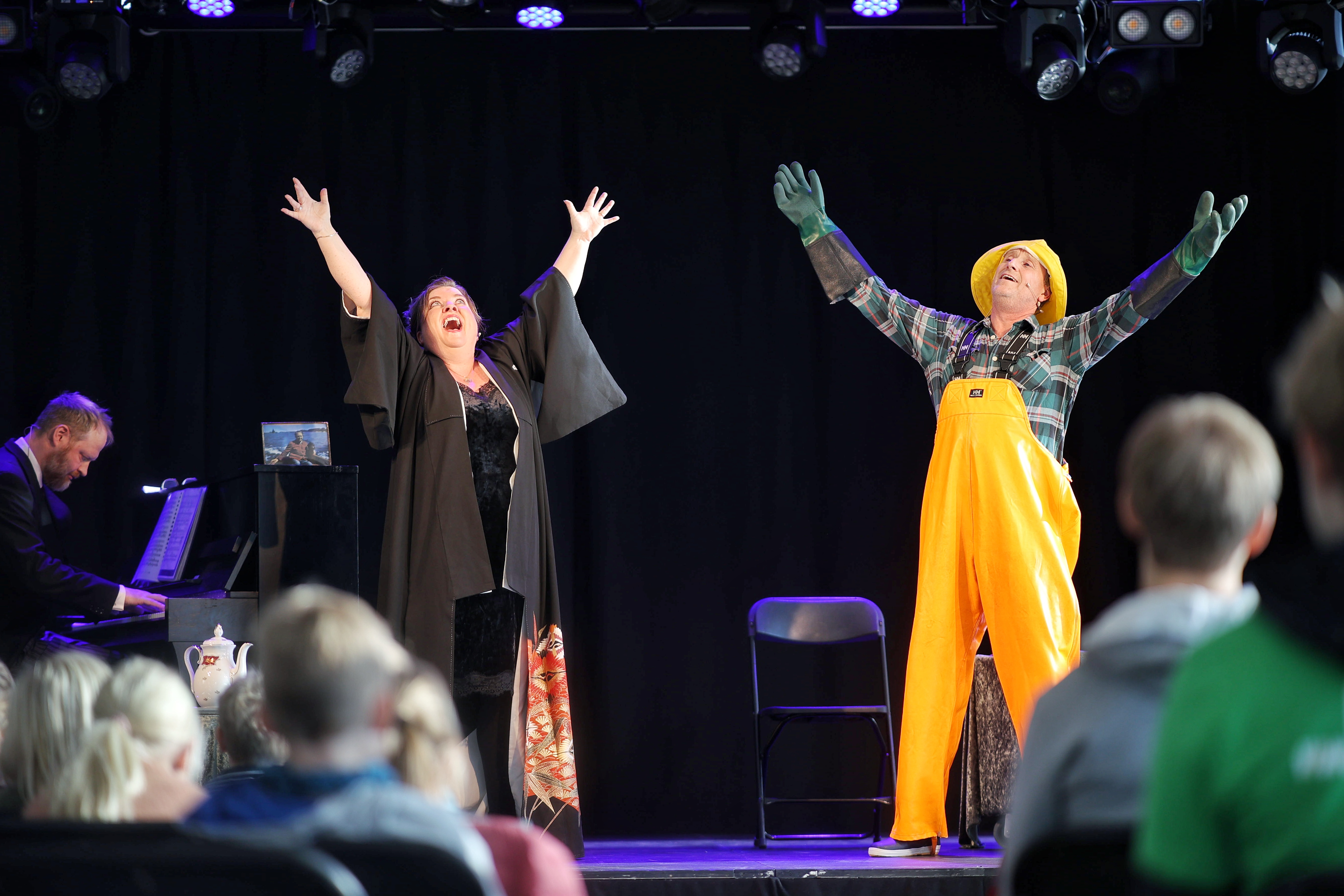 To utøvere står på en scene med hendene i været.