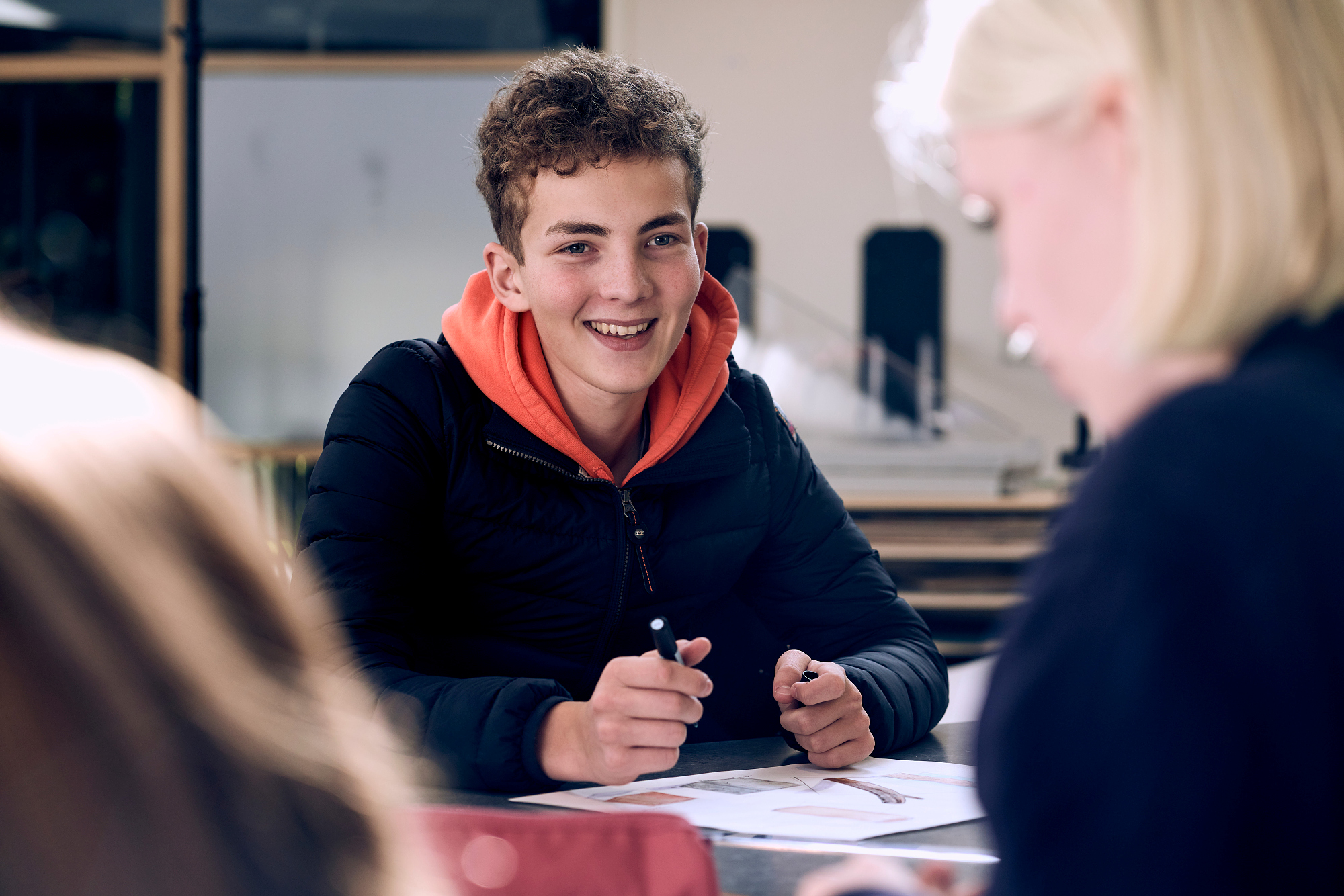 Gutt som sitter ved et bord med penn og papir