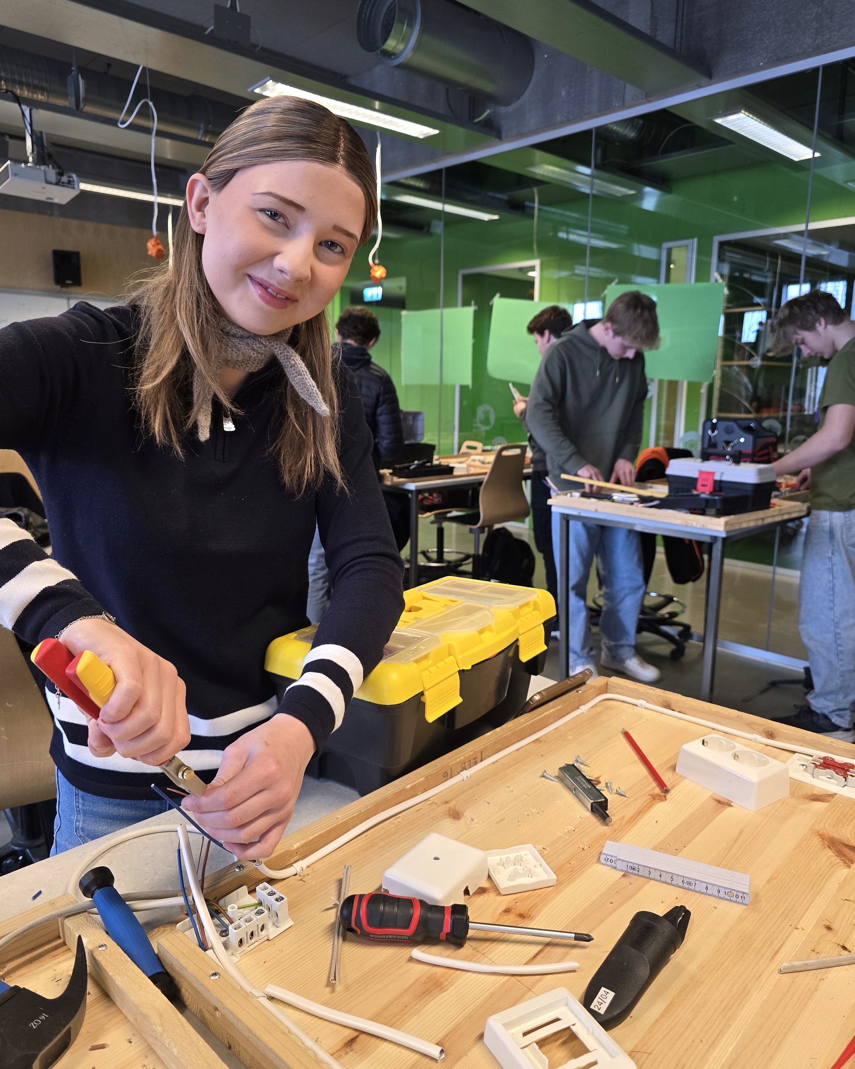 Alice mens hun jobber med kabler.