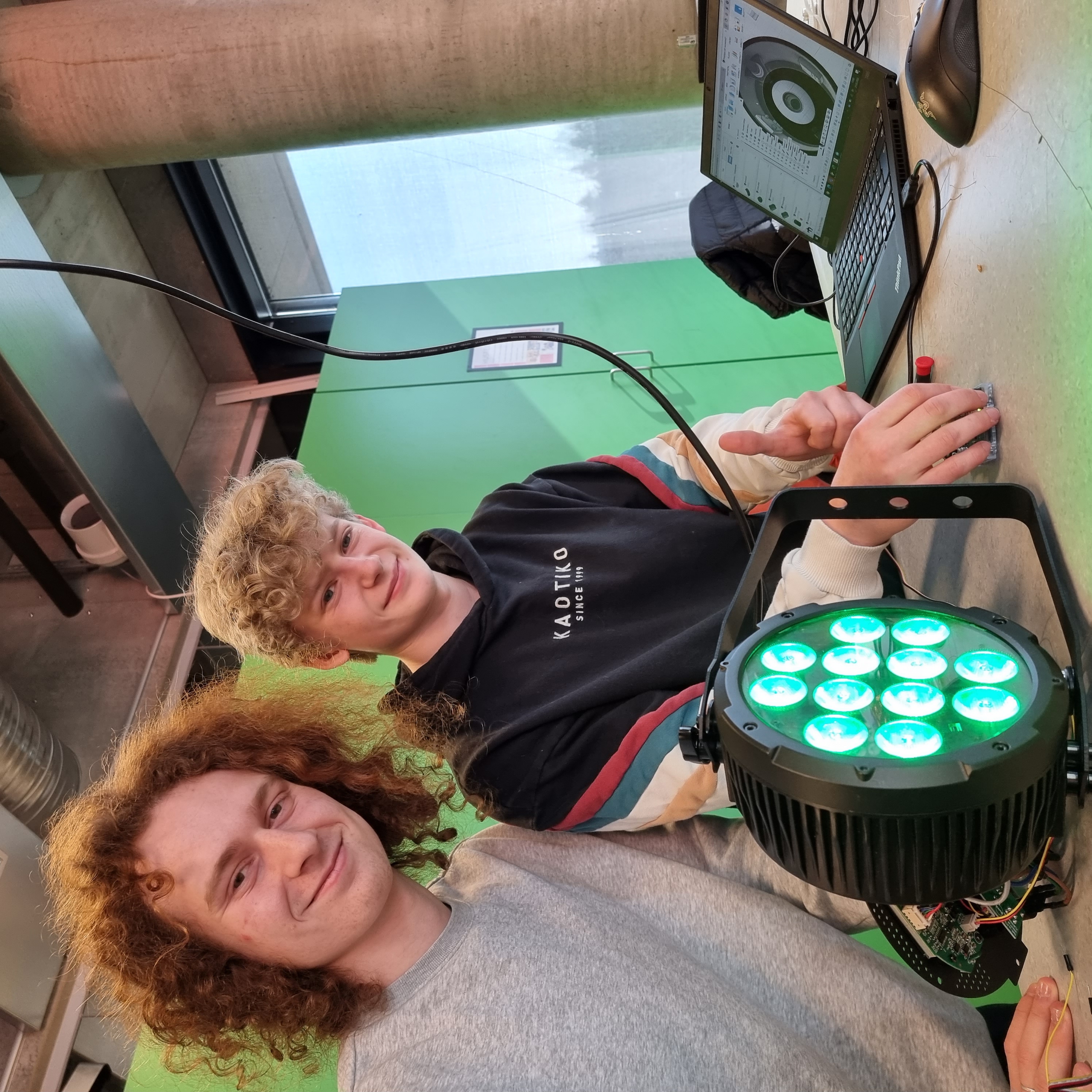 To elever som jobber med lyskaster.