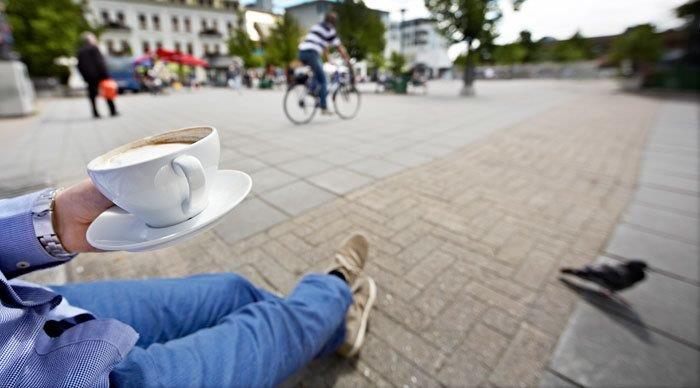 Gateliv med kaffe på benk i bymiljø