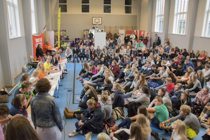 Mange elever og et panel med politikere i gymsal