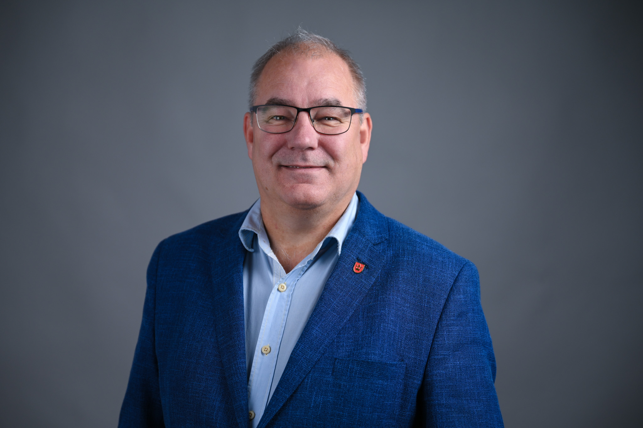 Portrett av mann med grå bakgrunn. Foto: Anders Palmer Holmen