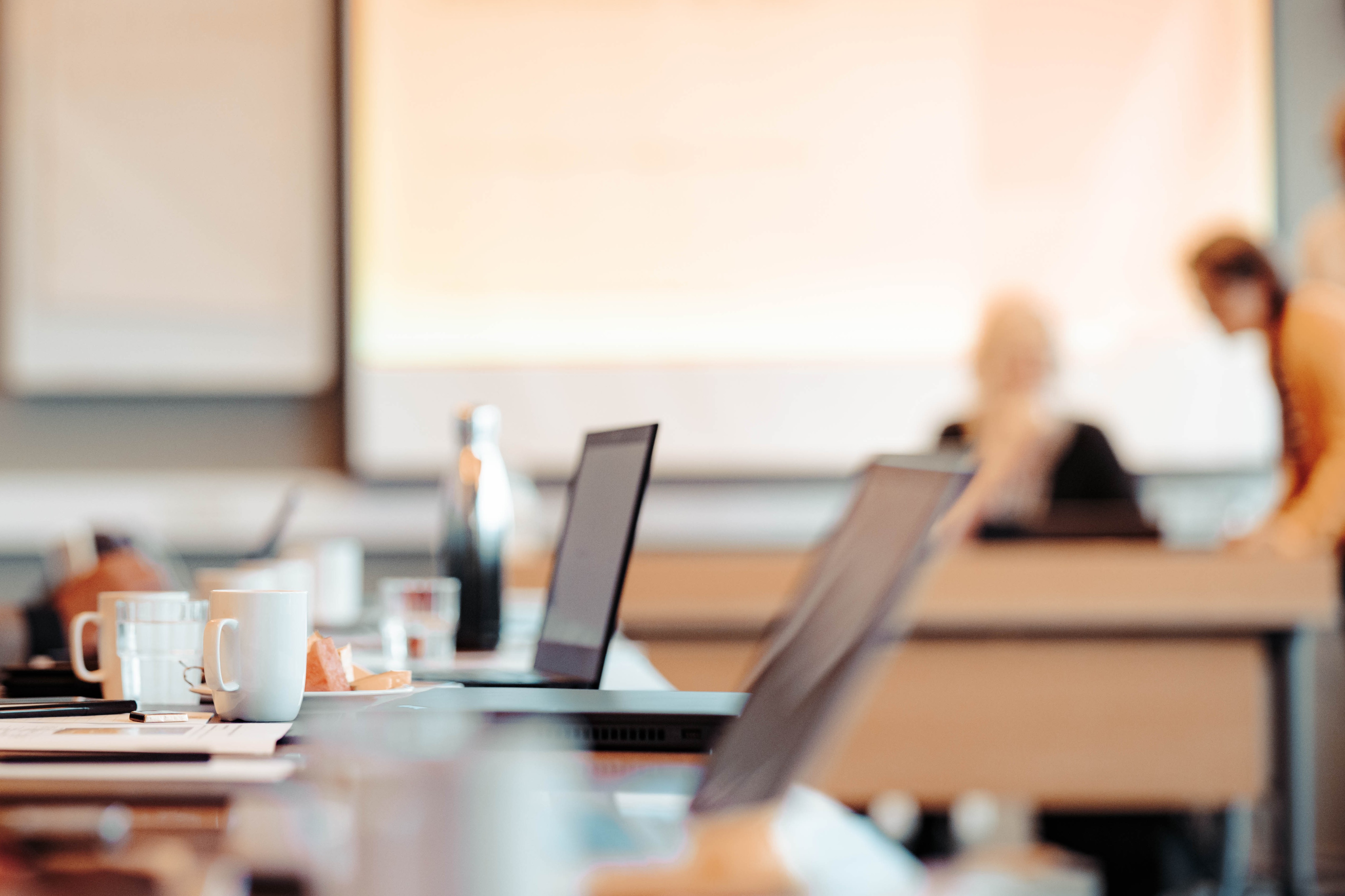 Illustrasjonsfoto av møtebord med pc, papir og kopper