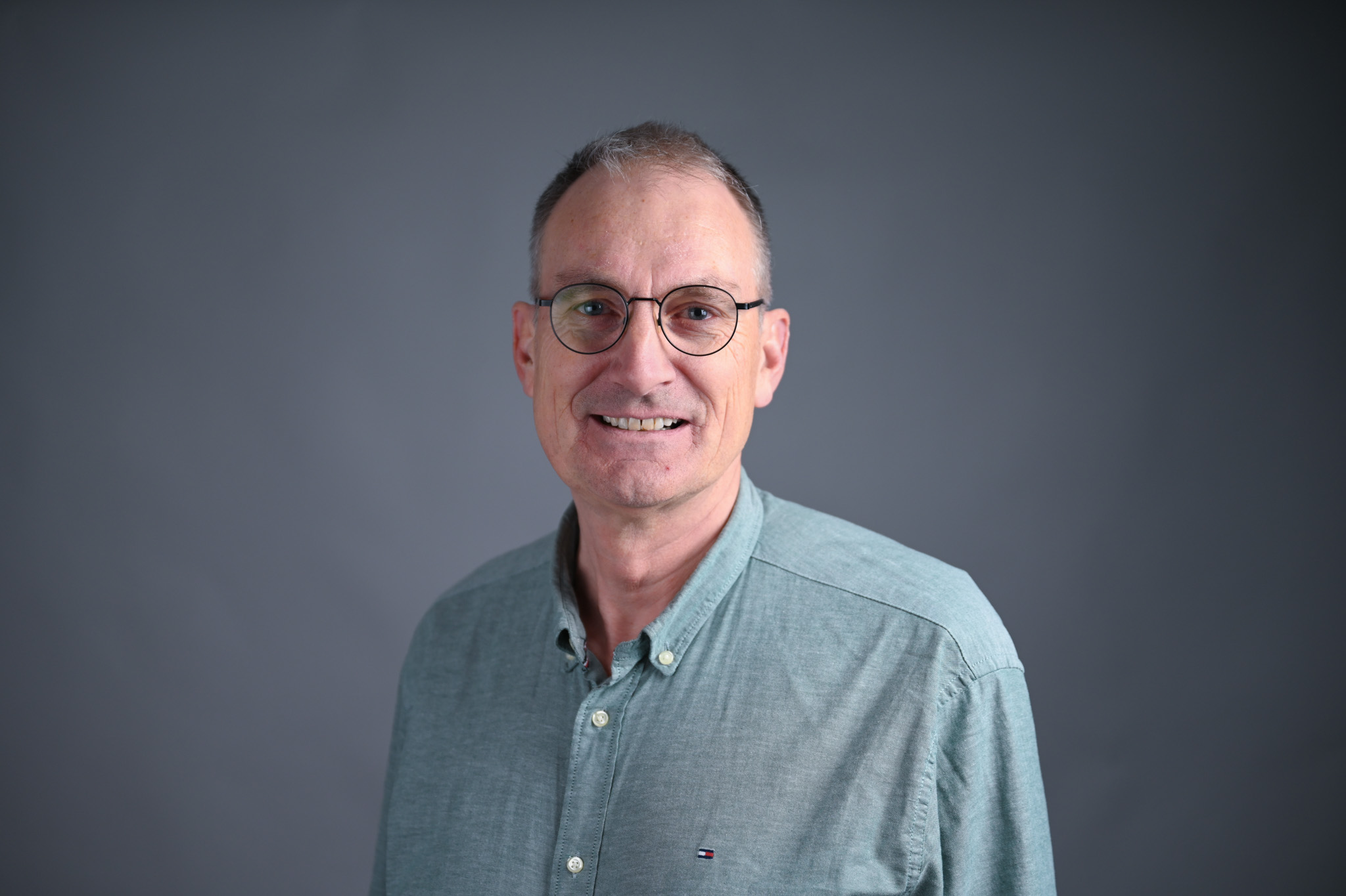 Portrett av mann med grå bakgrunn. Foto: Anders Palmer Holmen