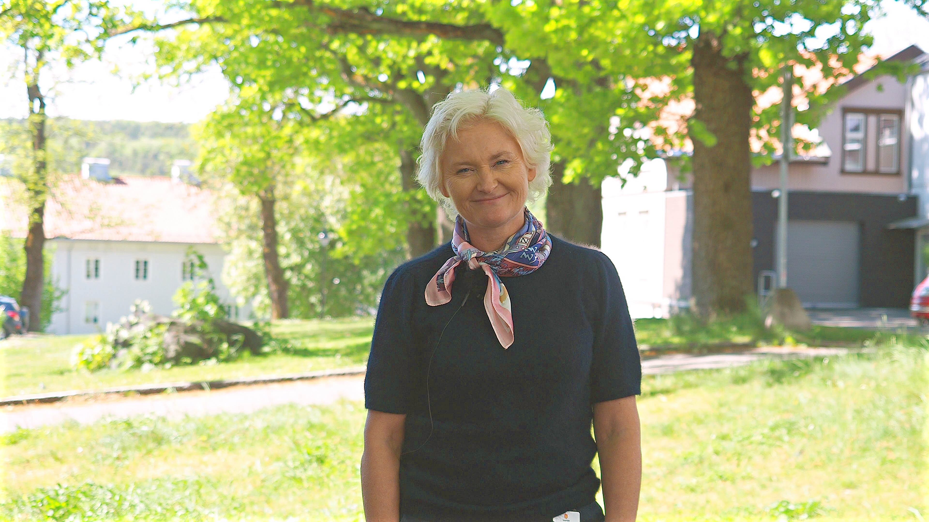 Foto med fylkesordfører Anne Strømøy foran parken utenfor Fylkeshuset i Tønsberg