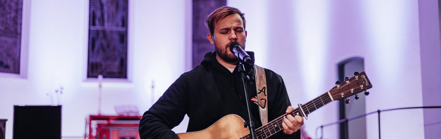 En man spiller gitar og synger.