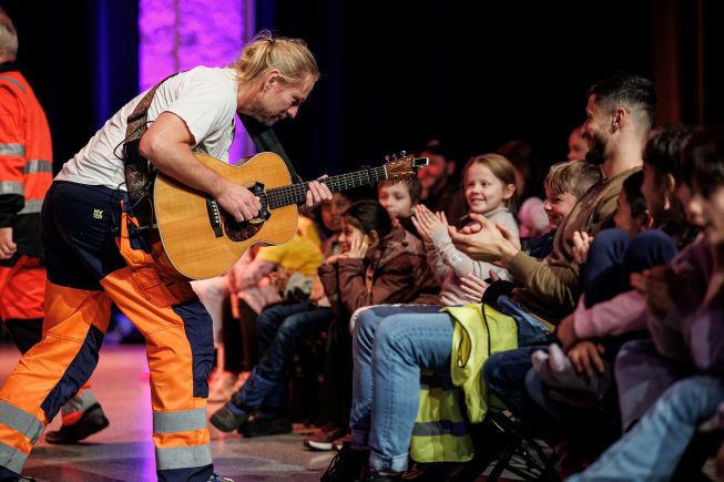 Musiker med gitar som opptrer for barn på Marked for musikk