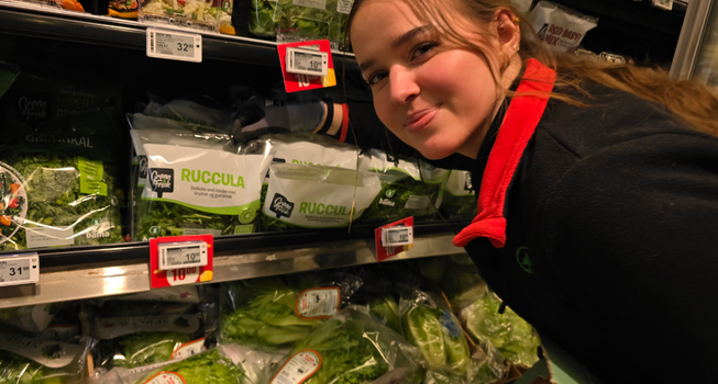 Elev som rydder i grønnsakshylla