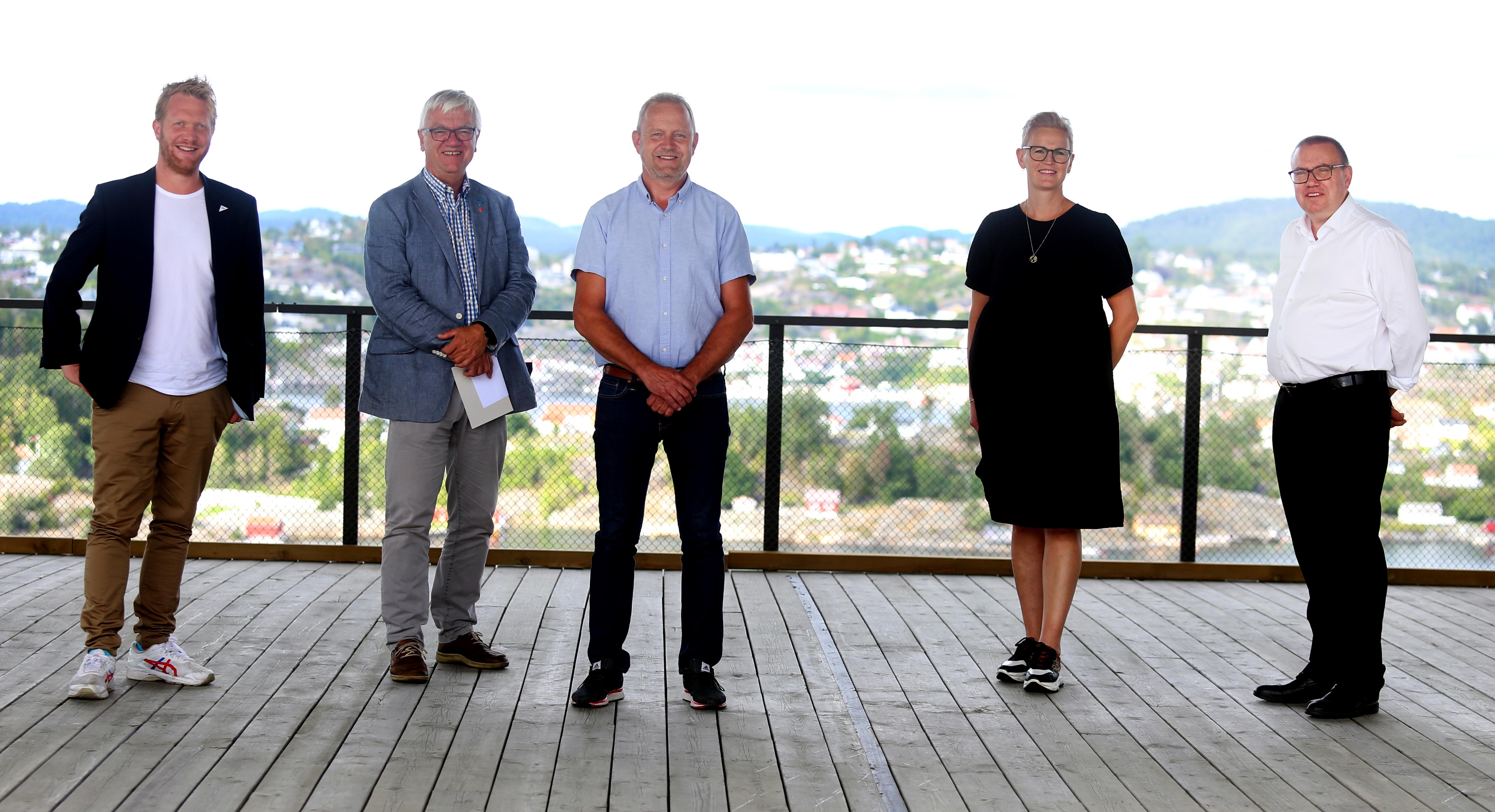 Fem politikere samlet utenfor Kragerø Resort, med Kragerø by i bakgrunnen.