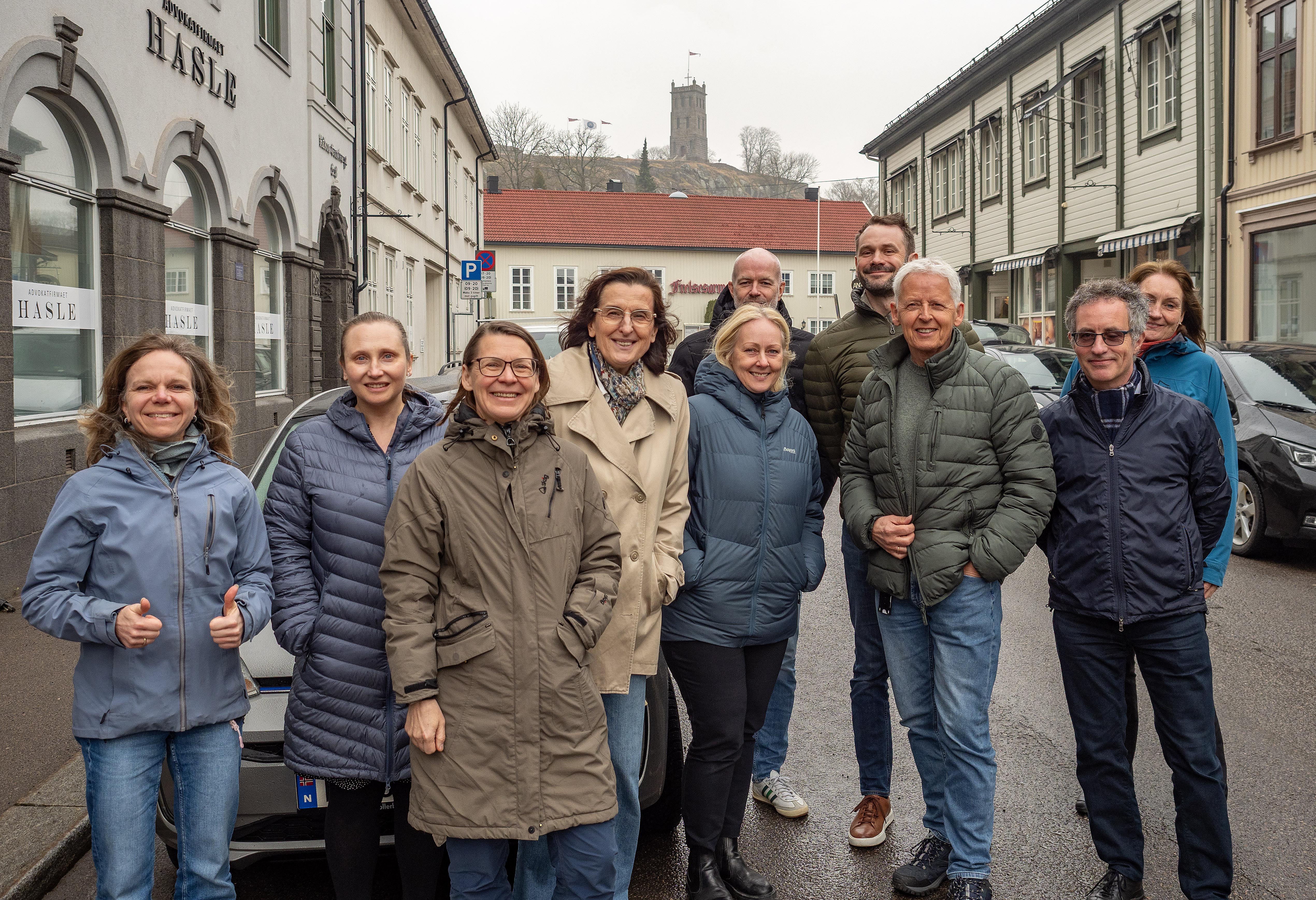 Foto av konsulenter i Norconsult og ansatte i Vestfold fylkeskommune og Bypakke Tønsberg-regionen i Tønsberg sentrum med Slottsfjellet i bakgrunnen