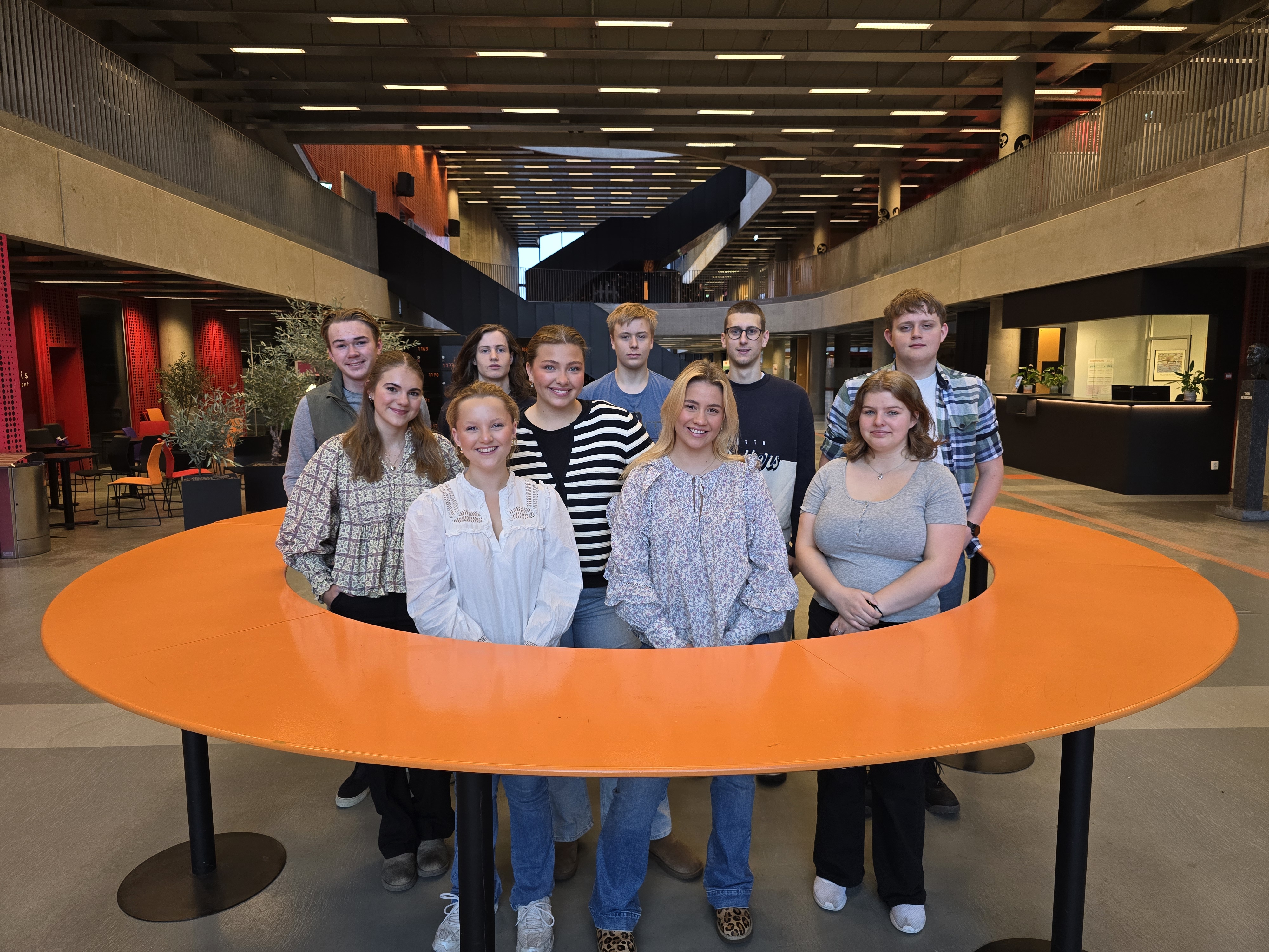 10 elever står samlet i skolebygget.