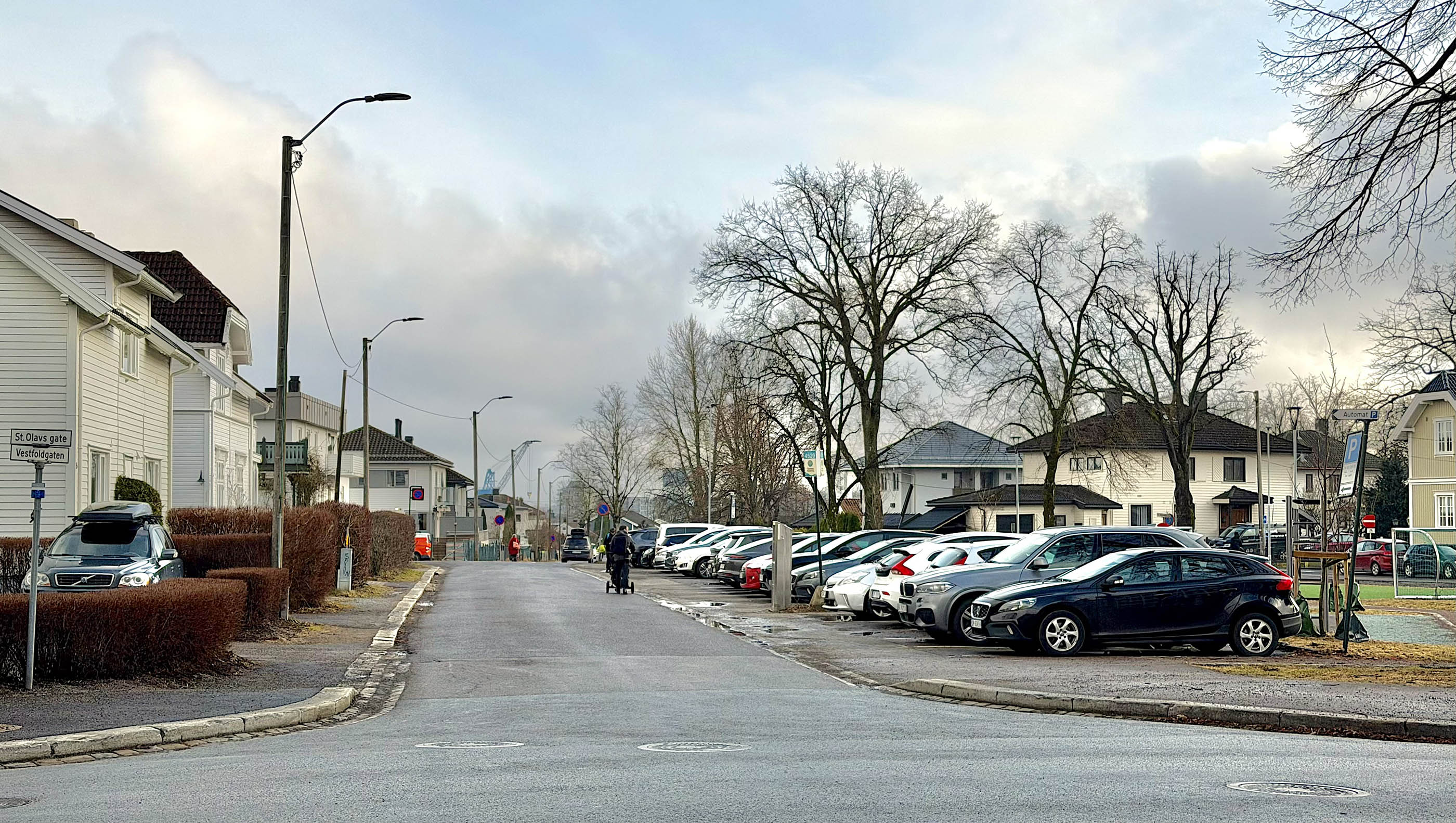 Fotografi av Vestfoldgaten i Tønsberg med folk og parkerte biler