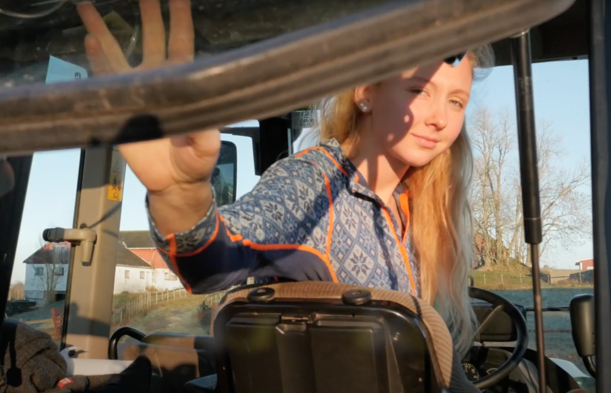 Smilende elev titter ut av bakvinduet på traktoren