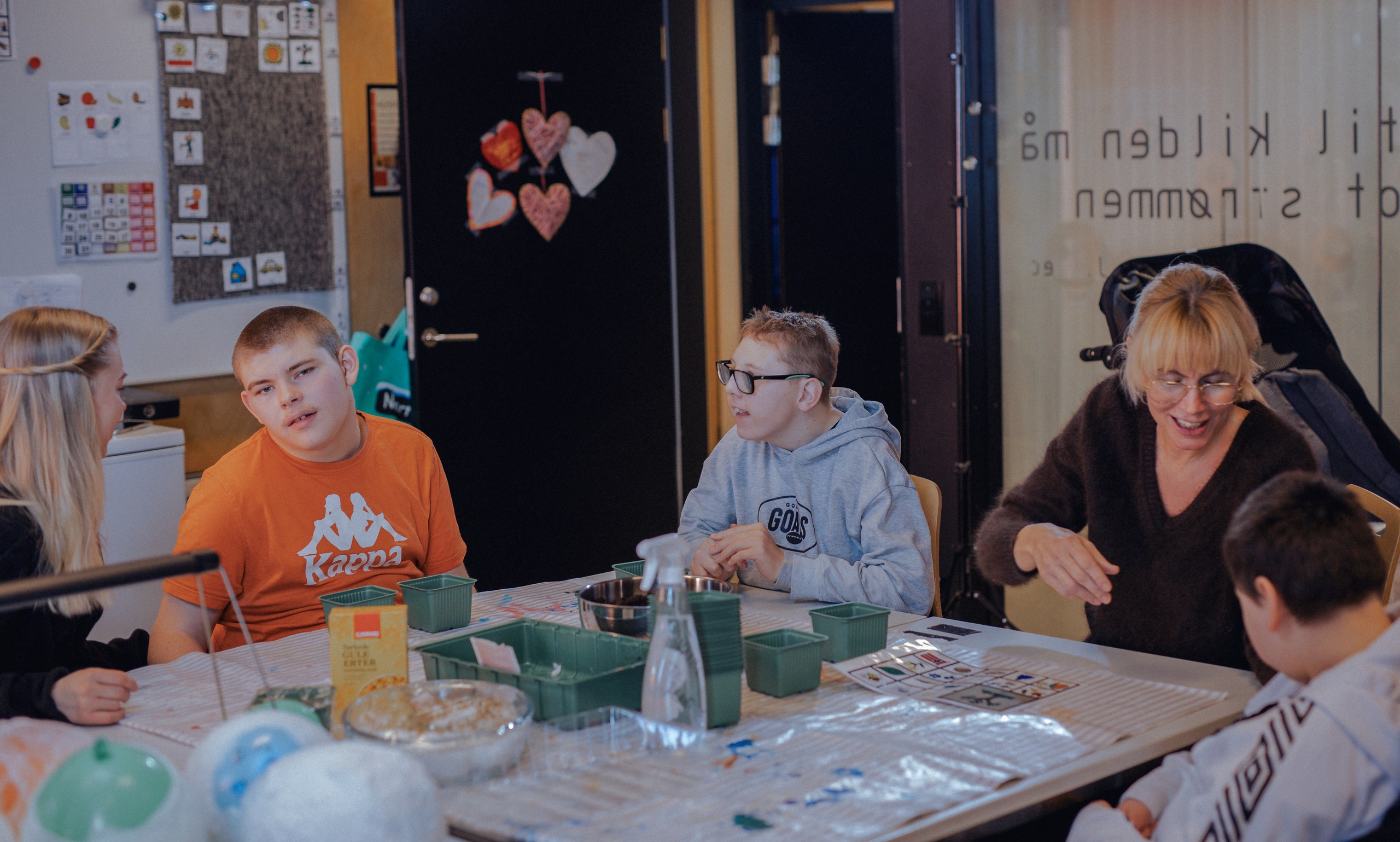 Elever og lærere rundt et bord der de planter frø.