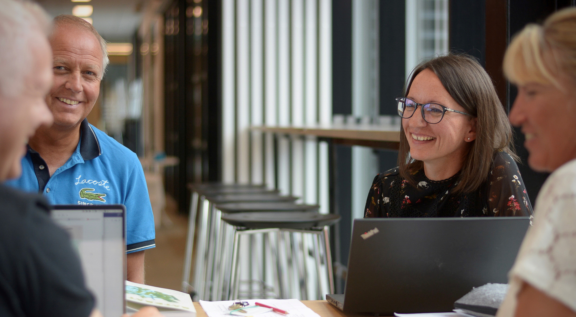 Kollegaer snakker rundt et bord