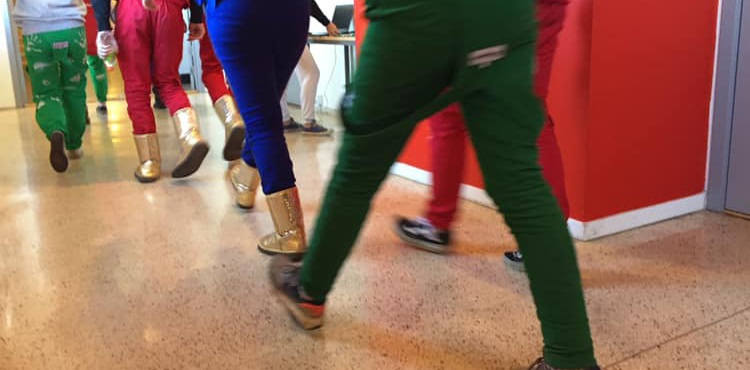 Bena til elever i russedress, som går i korridor, bakfra