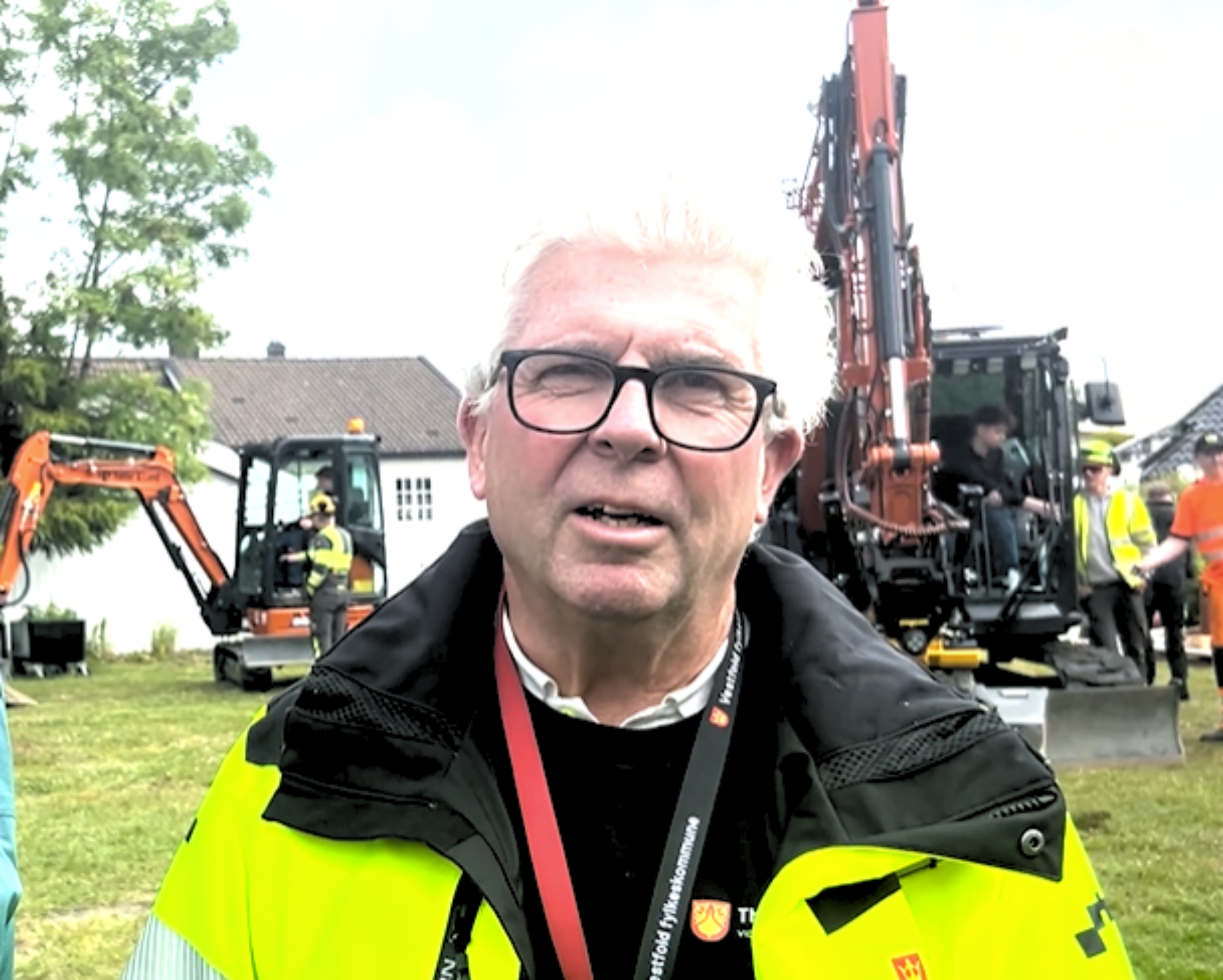 Bilde av Jan med gravemaskiner og ungdom i bakgrunnen.