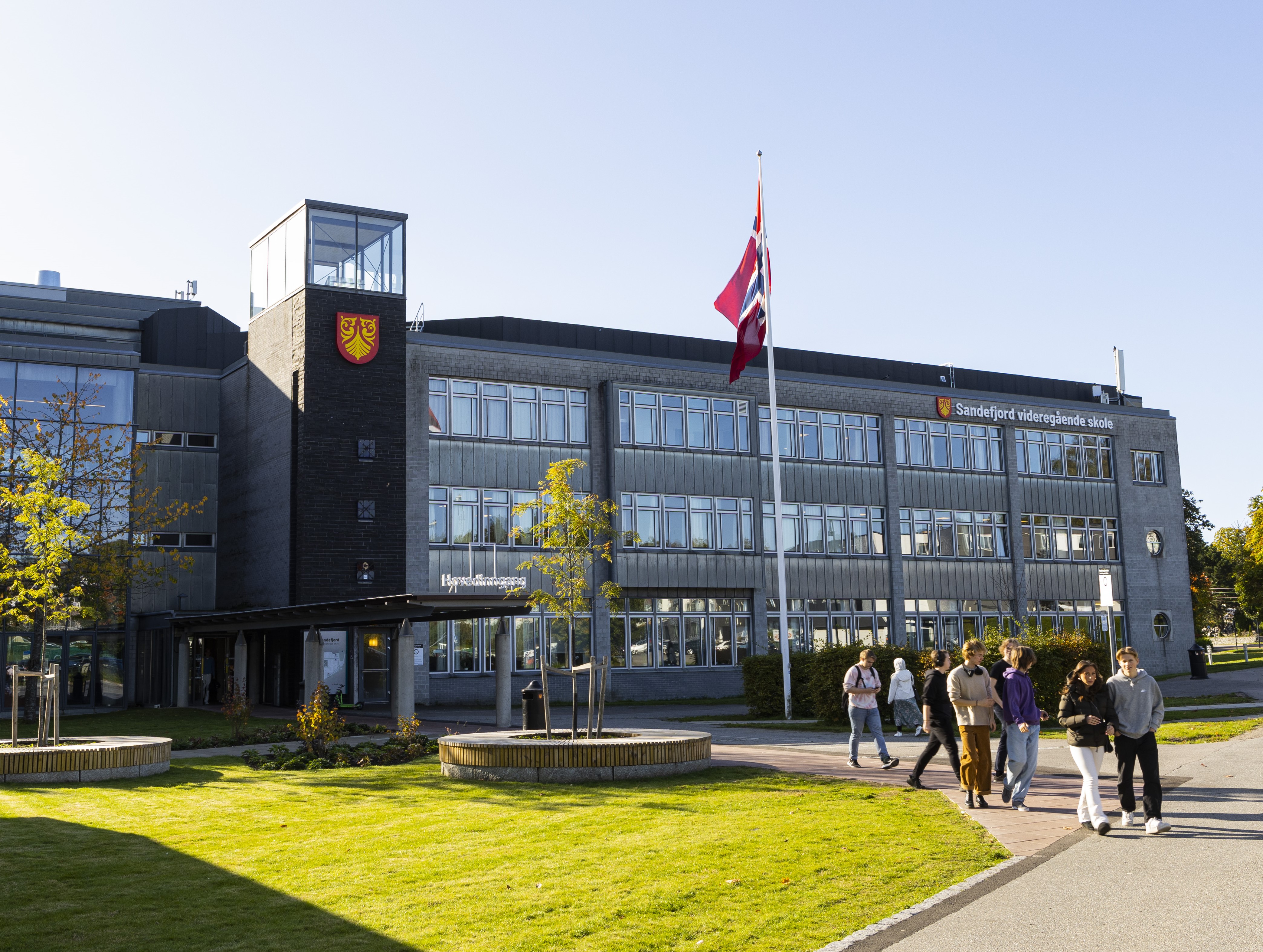 Skolens bygg, flaggstang med flagget til topps.