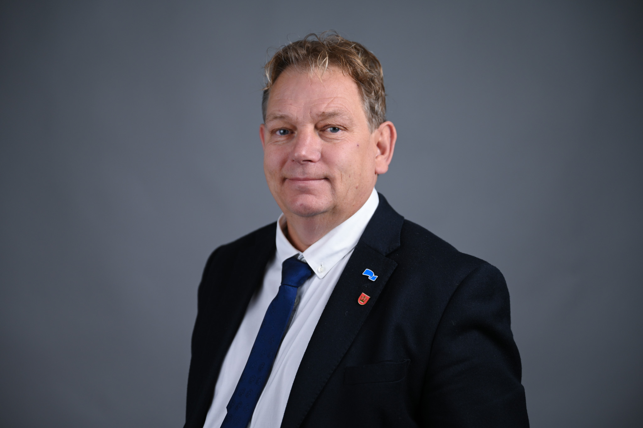 Portrett av mann med grå bakgrunn. Foto: Anders Palmer Holmen