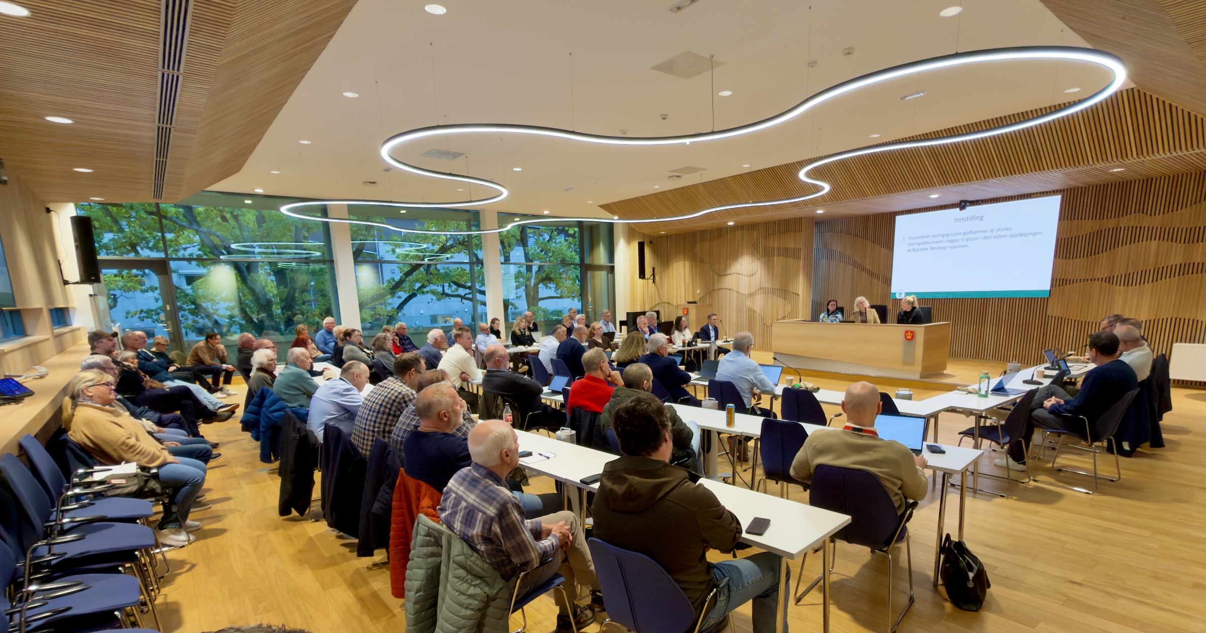Foto med mange personer tatt i Vestfold fylkeskommunes fylkestingssal da overordnet styringsgruppe i bypakke tønsberg-regionen hadde møte 15. oktober 2026