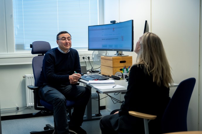 Veiledningssituasjon på kontor med mannlig veileder og kvinneligveisøker