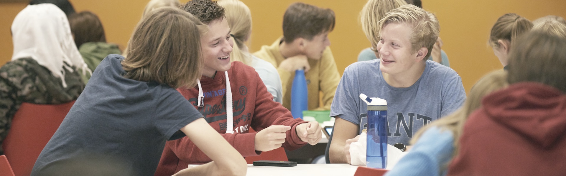 Elever som smiler og prater i kantina