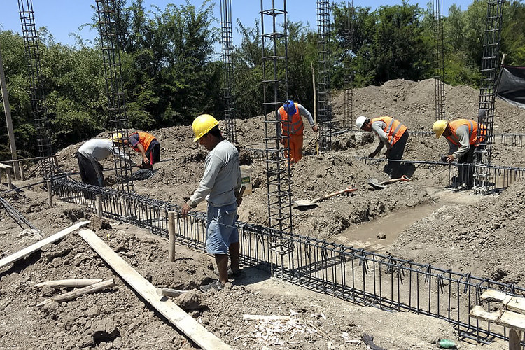 Bygningsarbeidere jobber med å bygge hus i mur