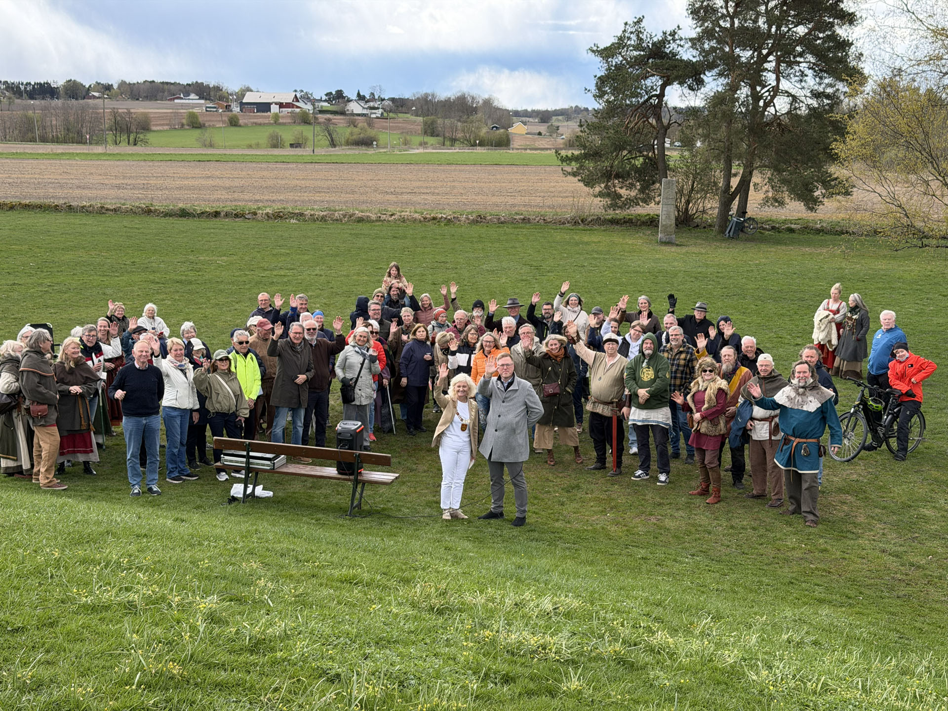 Fylkesordfører og ordfører foran en stor gjeng mennesker, en del er kledd i vikingklær.