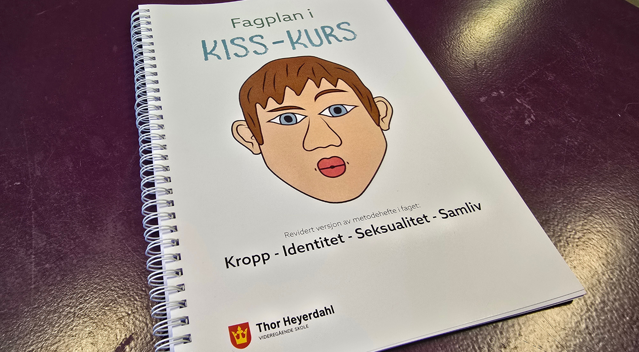 Bilde av heftet som ligger på et bord.