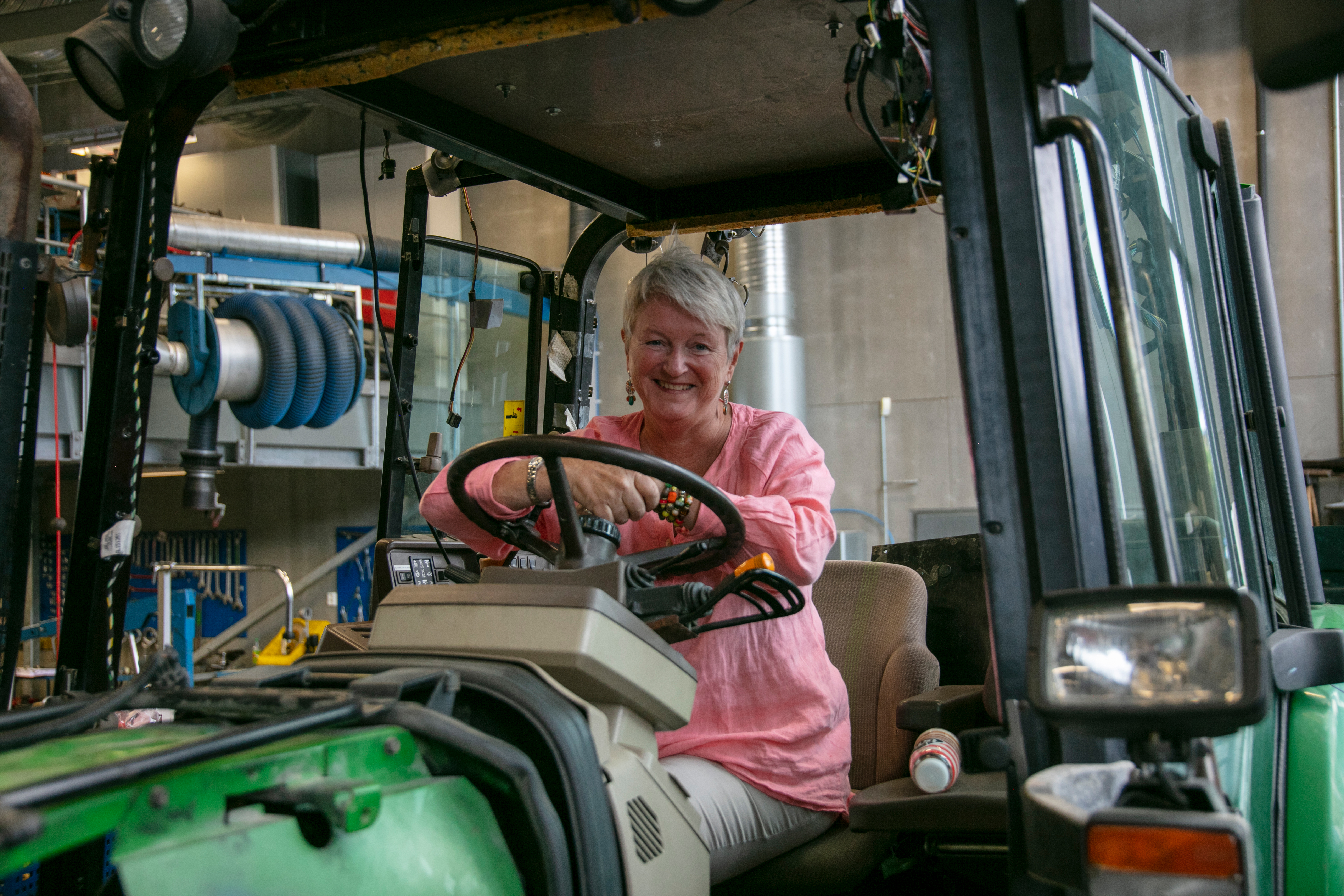 Rektor sitter i traktor inne på et av skolens verksted.