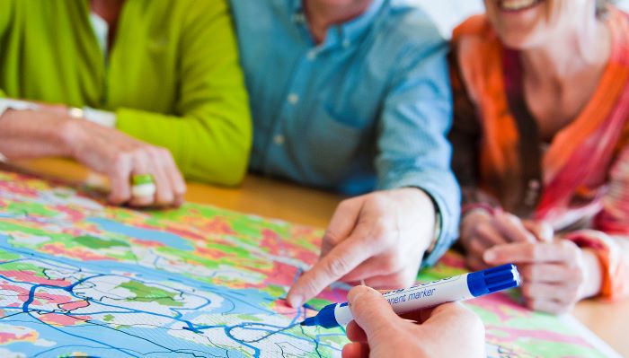 Foto av fire personer over et kart