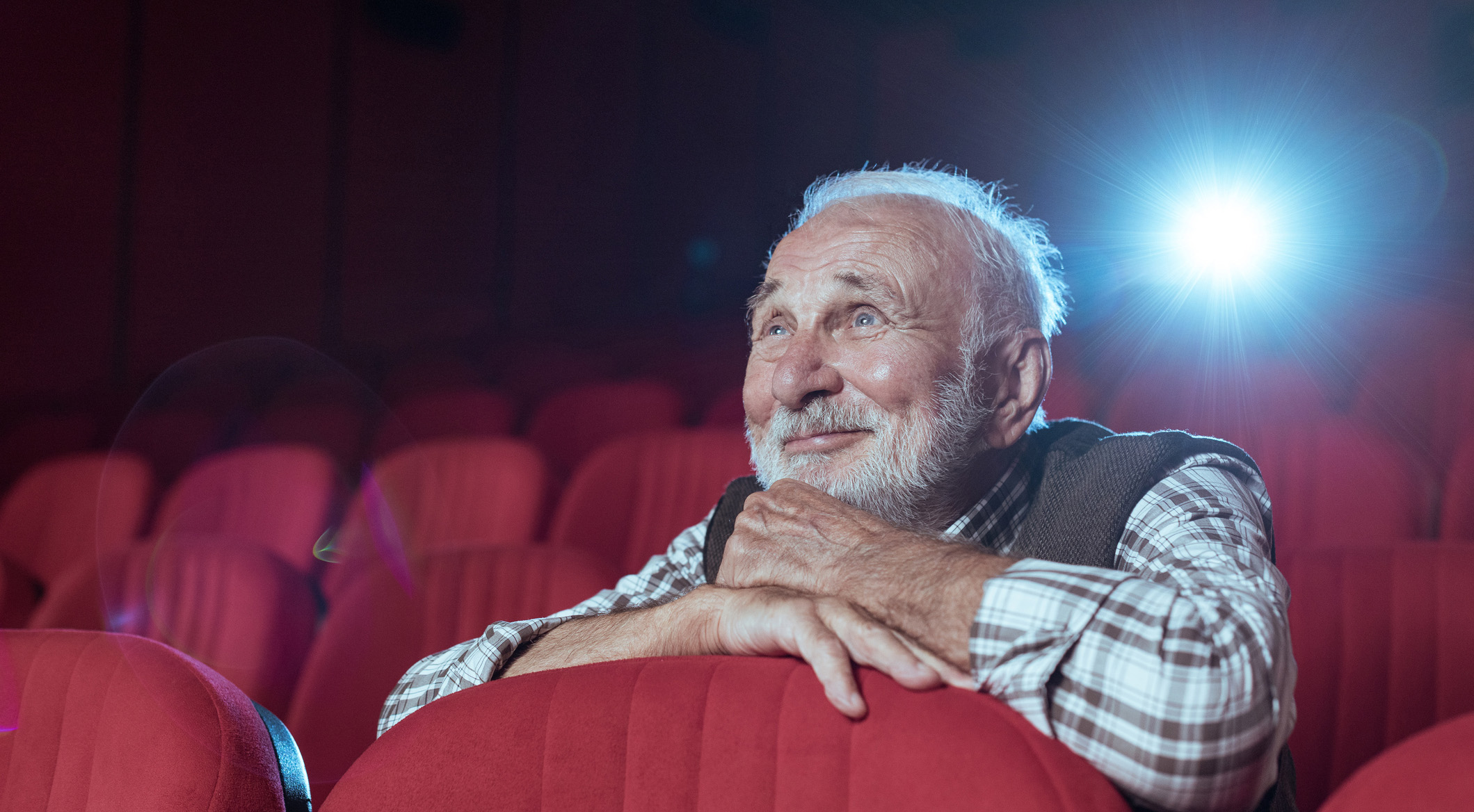 En eldre herre som ser film i en kino