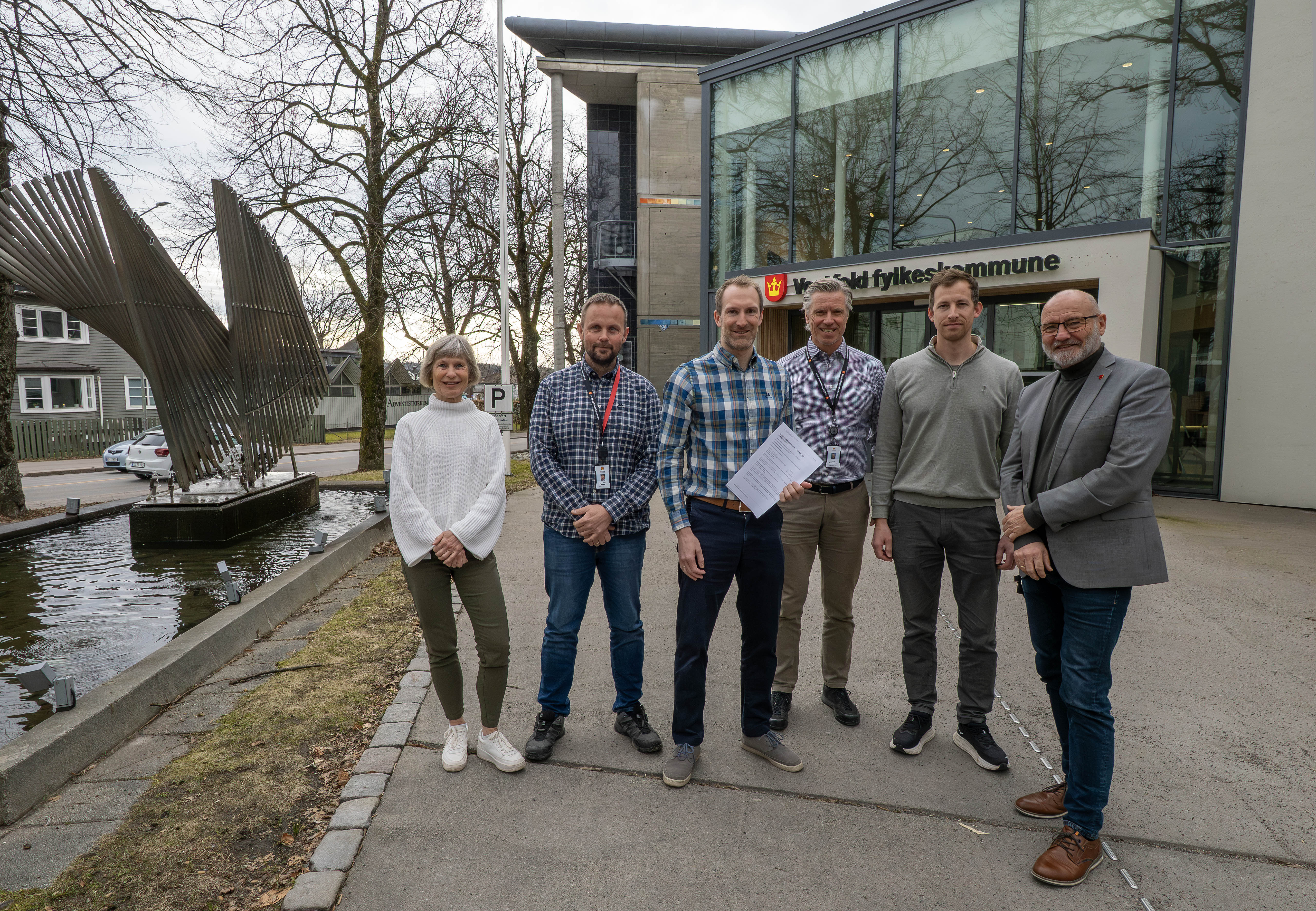 Foto av glade personer utenfor fylkeshuset i Tønsberg